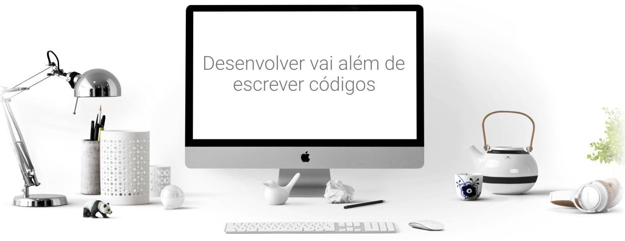 Área de trabalho com a frase na tela do computador: Desenvolver vai além de escrever códigos.